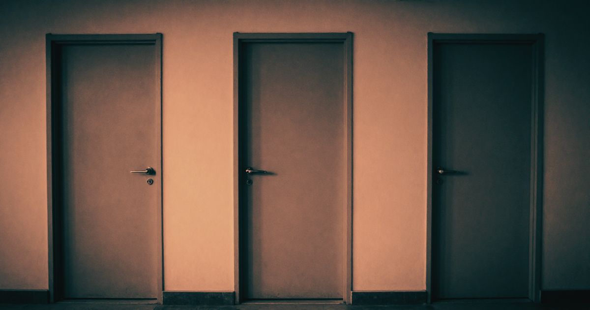 Three identical closed doors in a row along a plain corridor, indistinguishable from one another