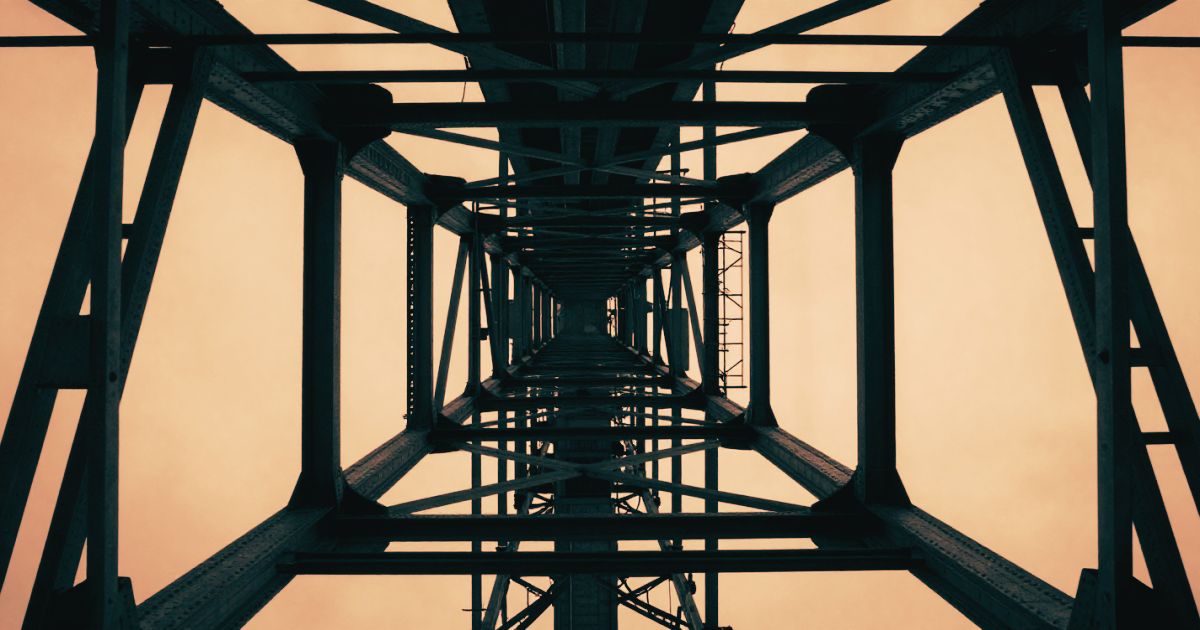 Looking straight up at a steel bridge structure from directly below, geometric and load-bearing
